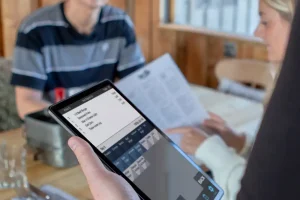 Staff member taking a tableside order using a PocketTouch device
