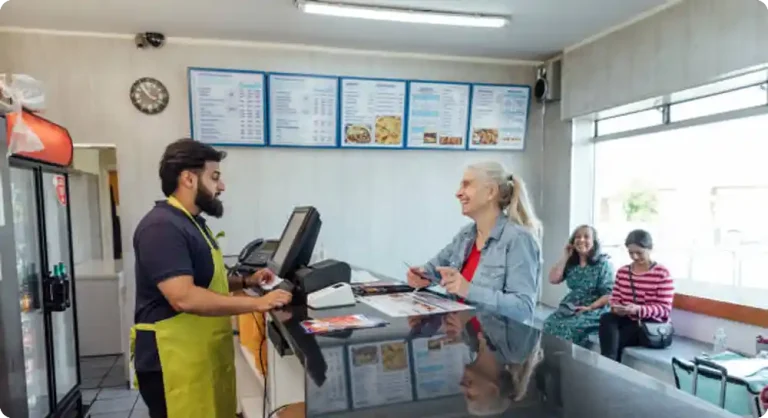 Customer placing an order at a pizza shop counter