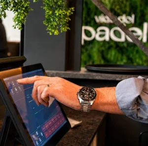 A hand operating a responsive touchscreen till on a modern EPoS system.